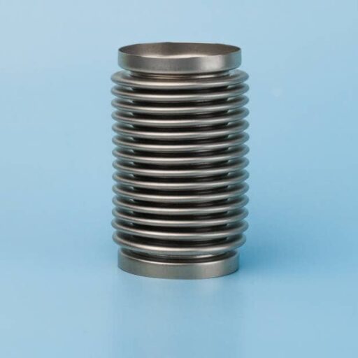 A silver metal bellows sits on a completely blue surface and in front of a background with the same color.