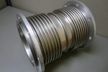 Caterpillar style expansion joint with integral floating flanges and center spool